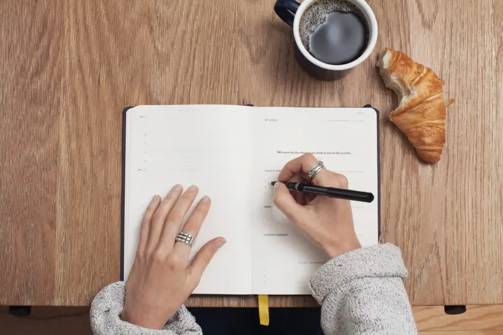 a professional secretary taking notes with a cup of coffee and a crossaint