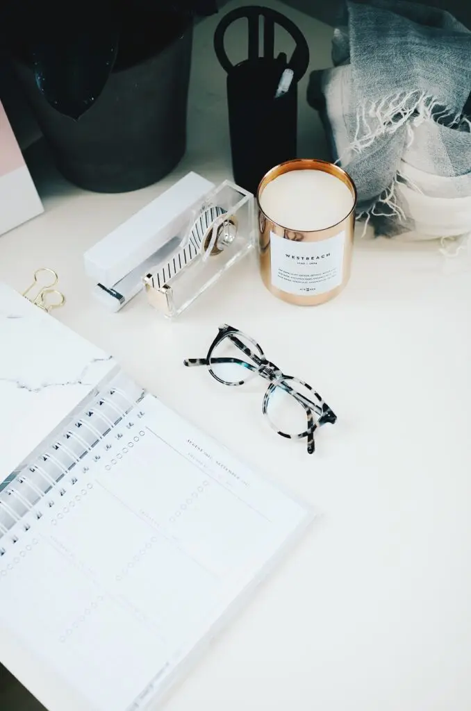 a clean desk space with notebook ready for taking notes for a meeting with reading glass and other office supplies in clean