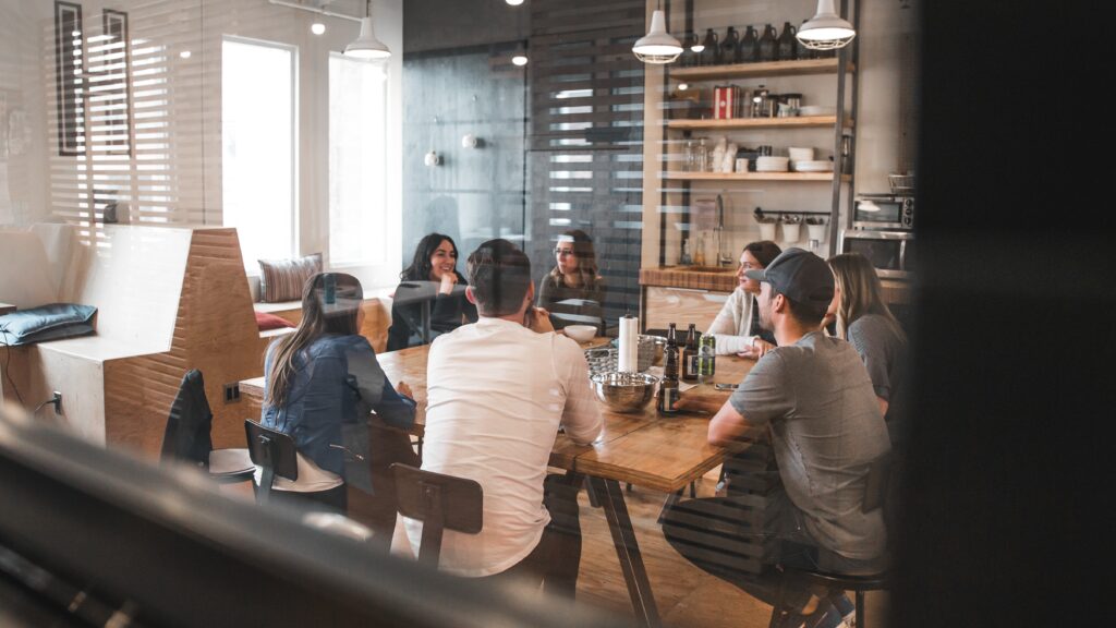 a group of professional after work discussion with bottles of beer on their middle desk with professional smiling to each other
