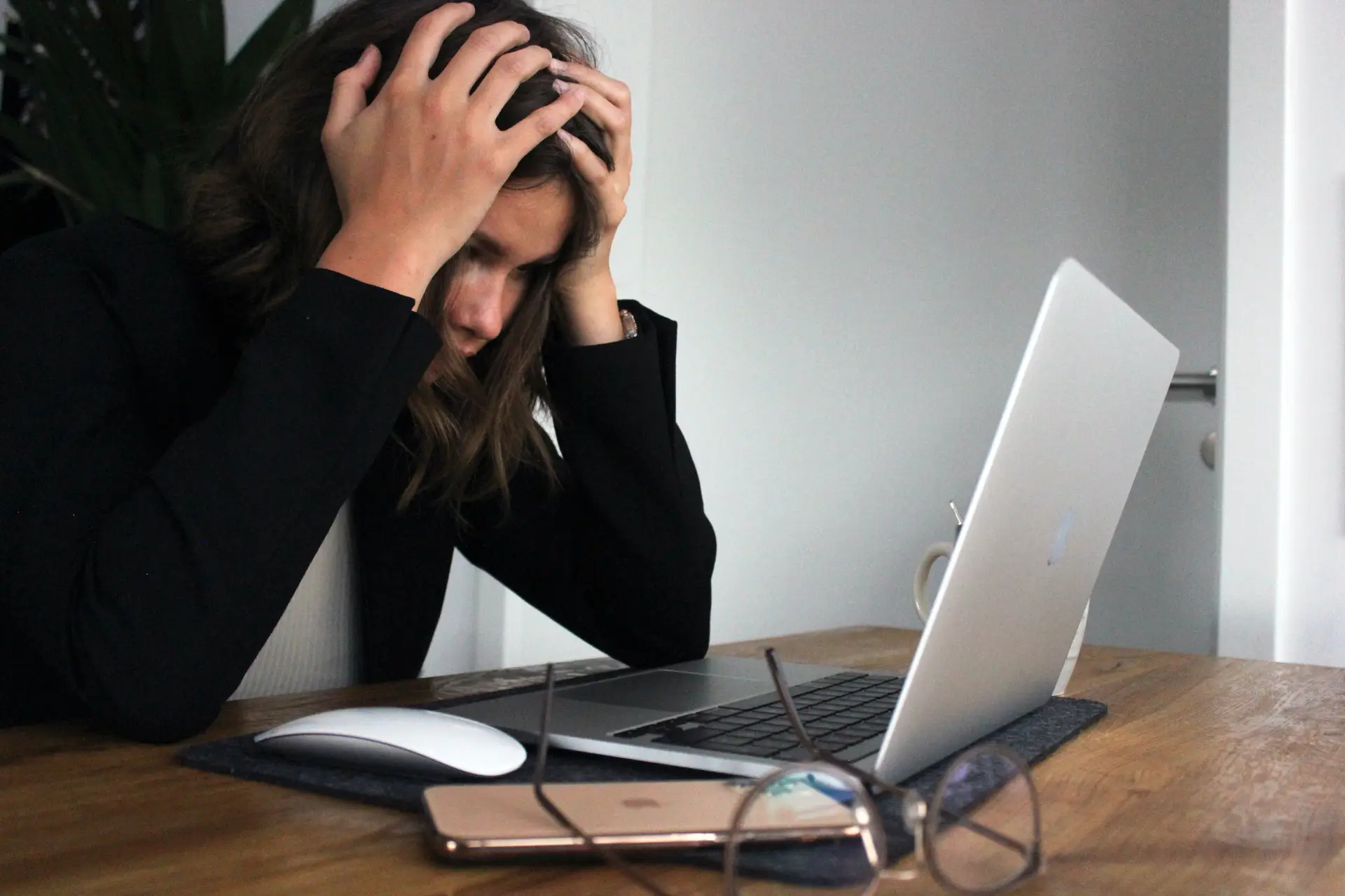 breakdown pose of a professional facing toward her laptop with his hand in her head