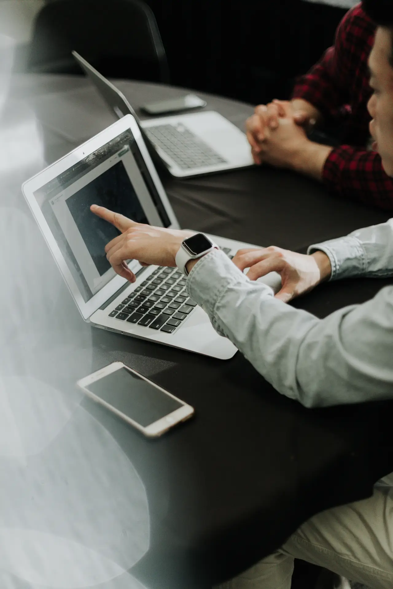 a professional marketing officer pointing his finger toward his laptop in a virtual meeting discussion
