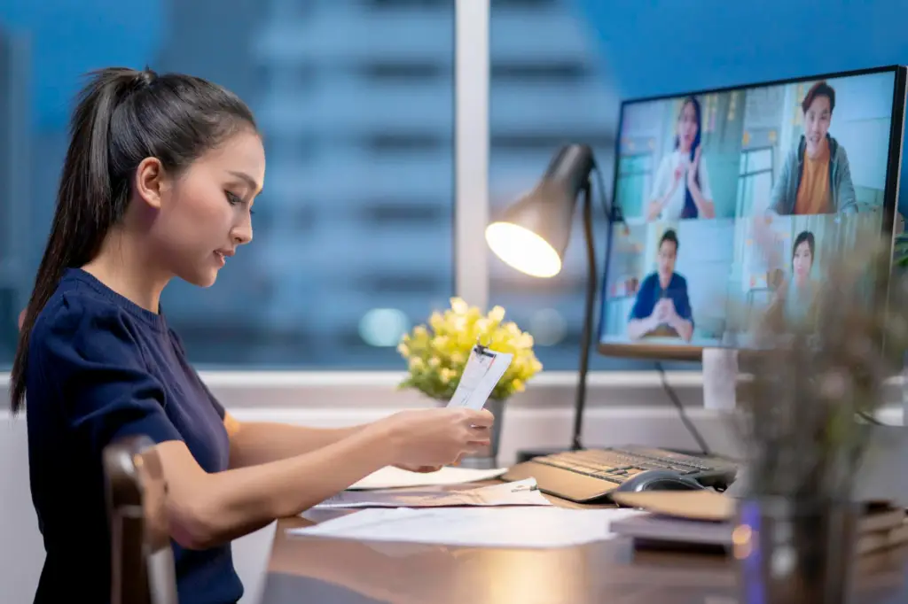 a good looking women facing his monitor with 4 difference virtual individual during a virtual meeting