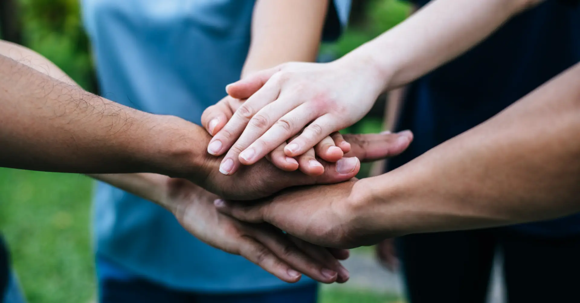 a group of hands placing on top of their palm symbolizing collaboration and teamwork